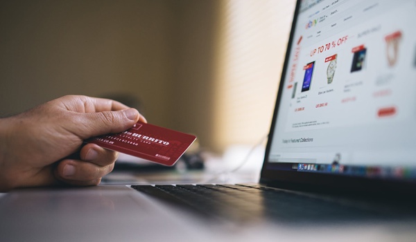 image of laptop and hand holding a credit card